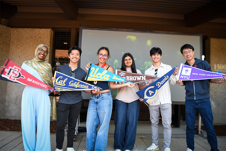 Students showing university pennants