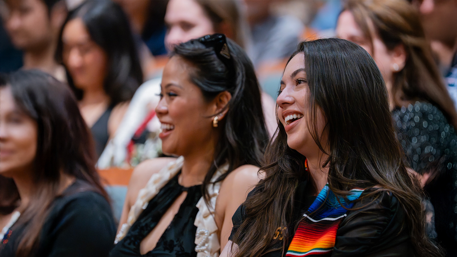 Female students smiling at a conference.