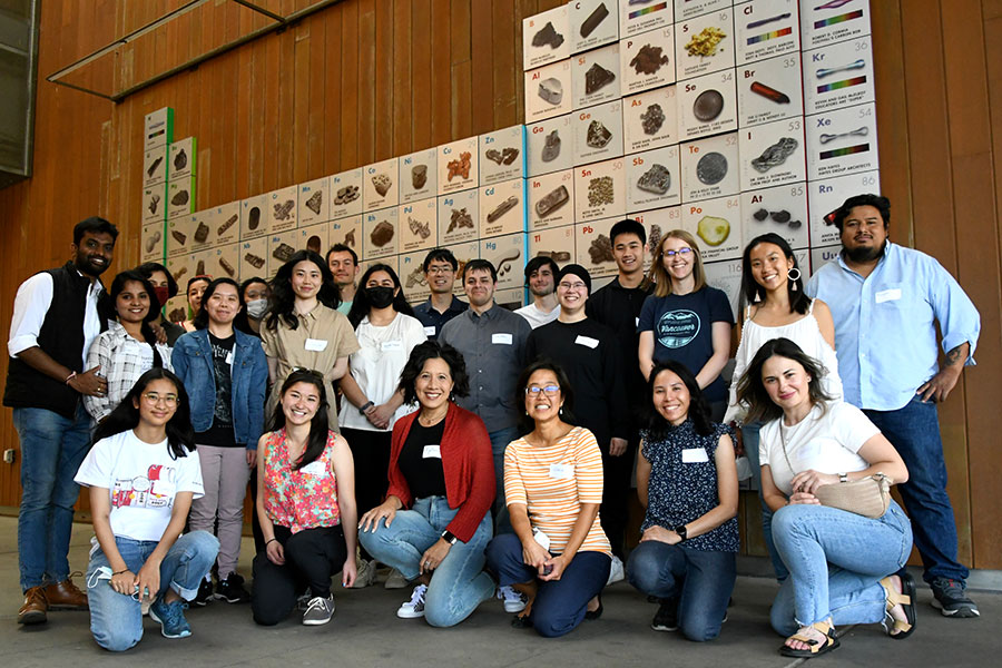 large group of students in front of periodic table mural