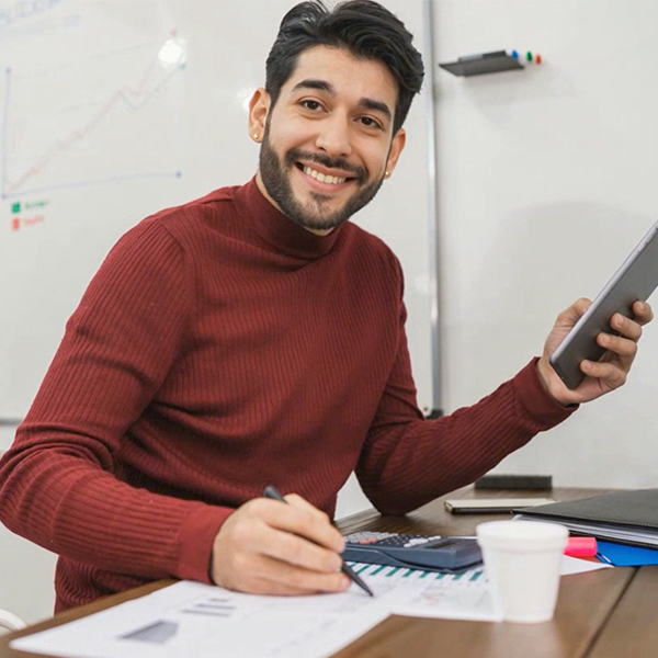 Accounting male smiling and making numbers with a calculator