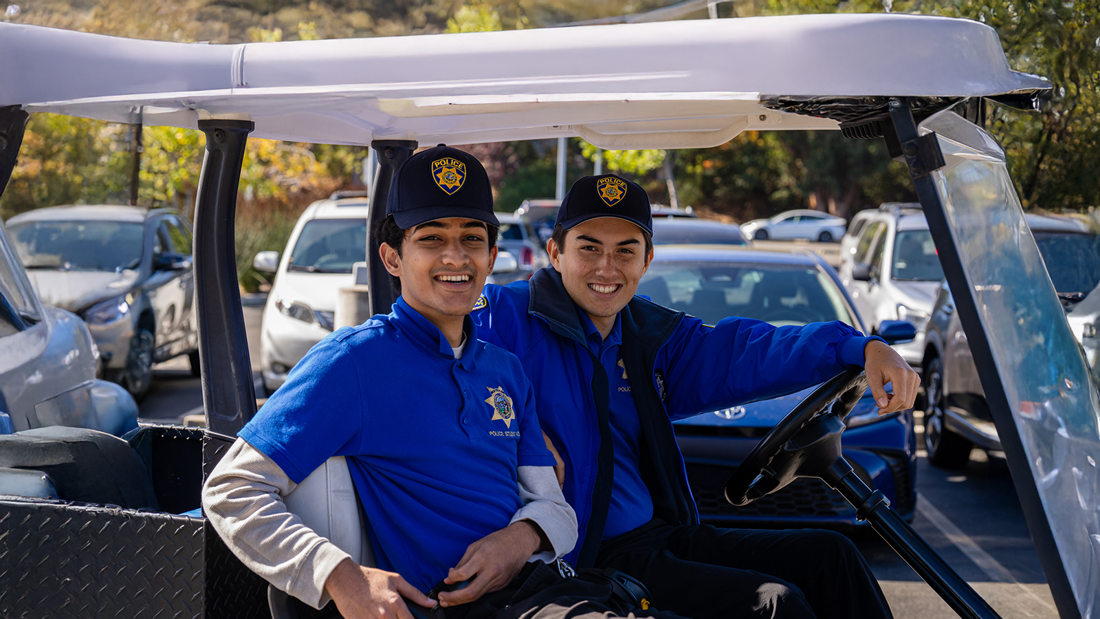 Two Foothill College Police Officers driving a golf cart