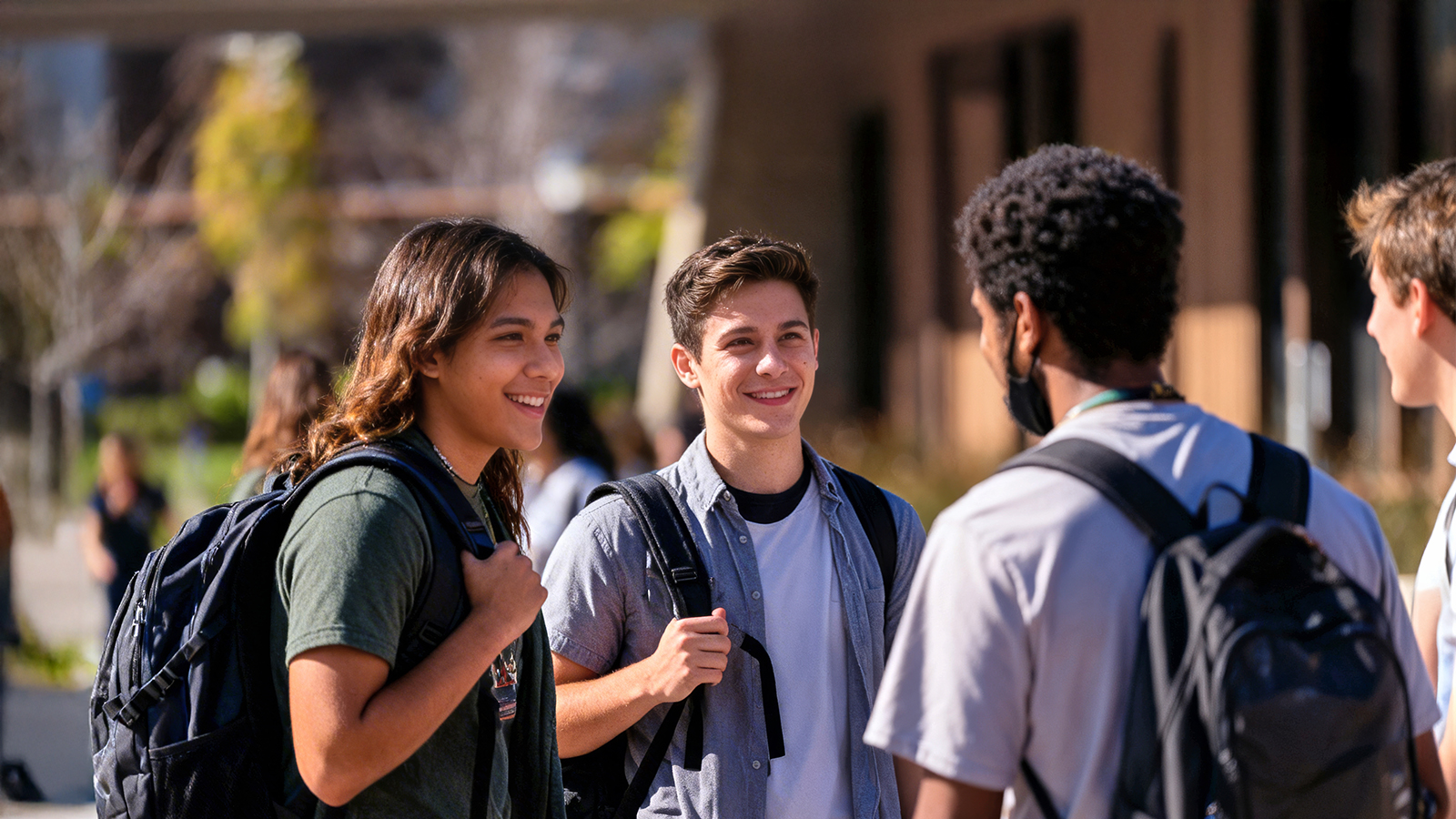 Three male students talking outside the Library Quad