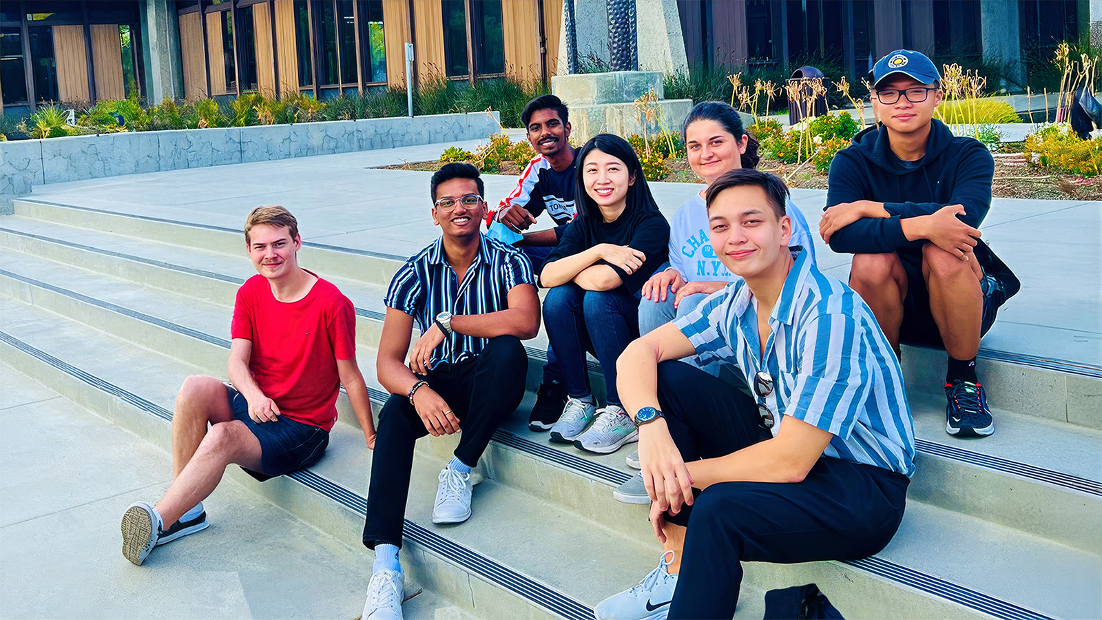 Diverse group of international students in front of the Library stairs.