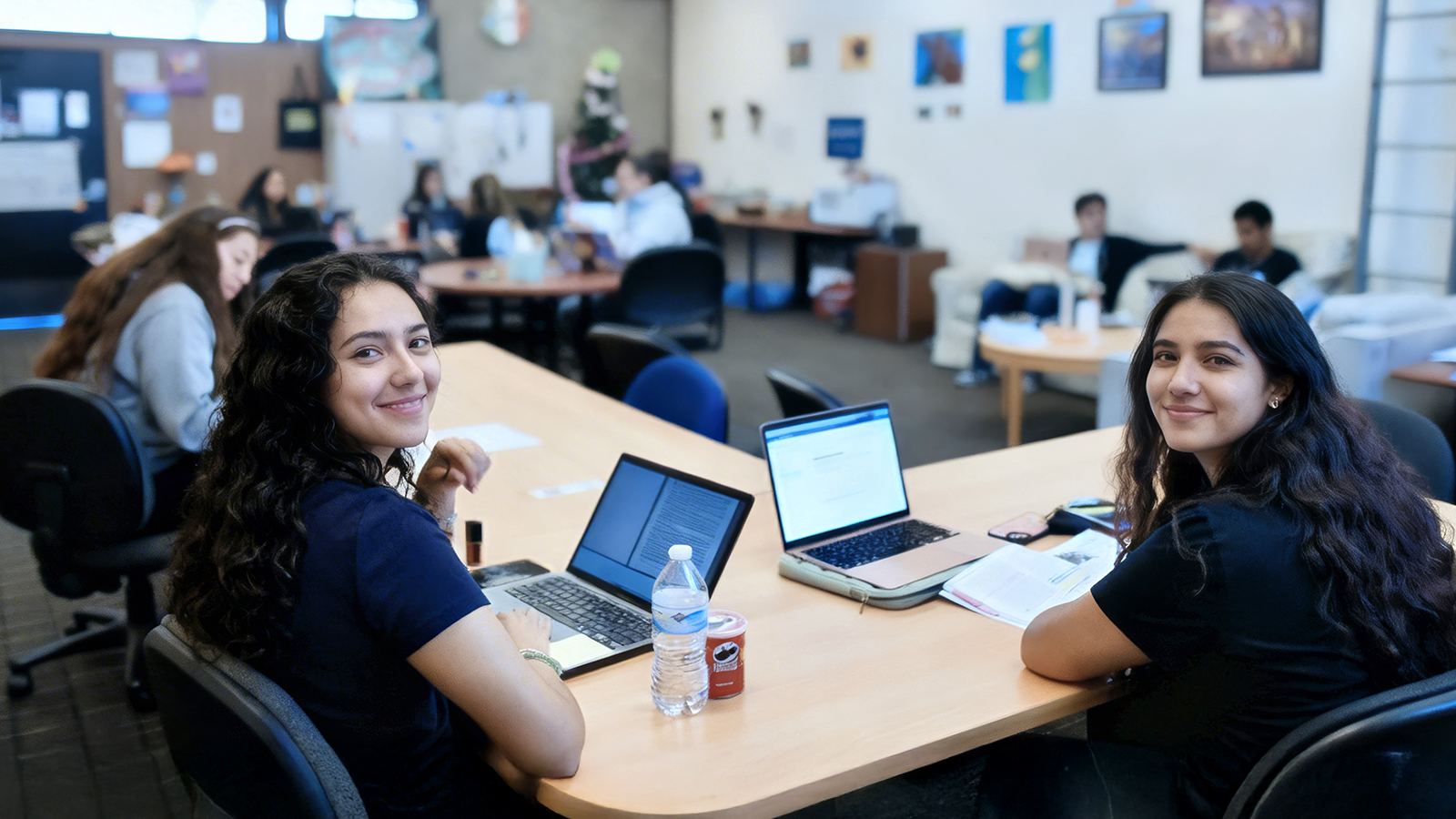 Two female students at class smiling