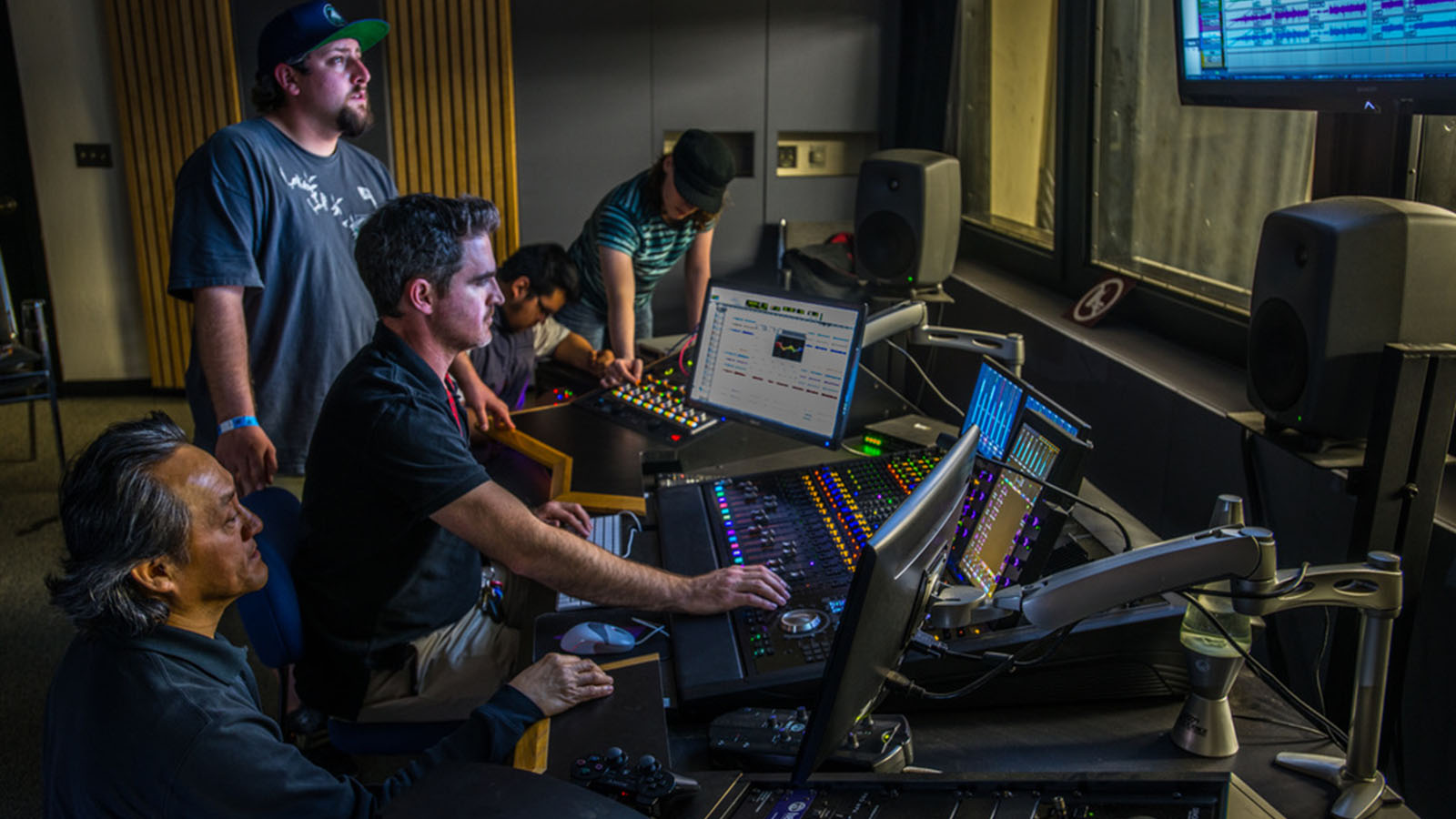 Audio engineers working at a professional mixing console in a sound production studio.