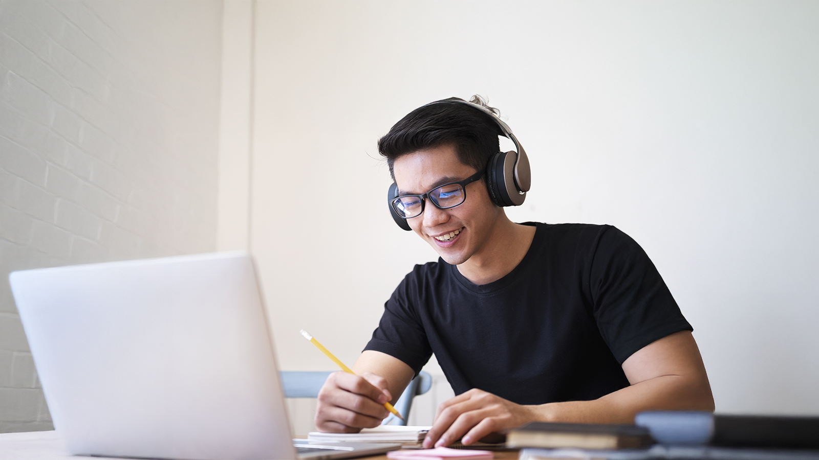 Asian male student at home taking online class