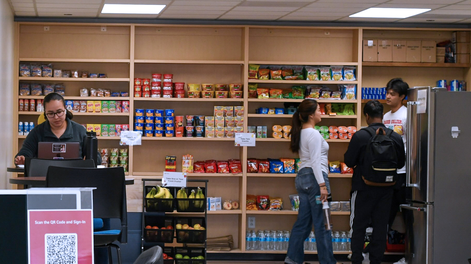 Divers group of students at Owl's Nest taking groceries