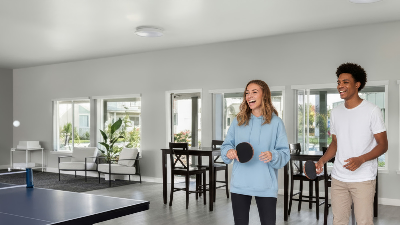 Two students playing ping-pong in the common room