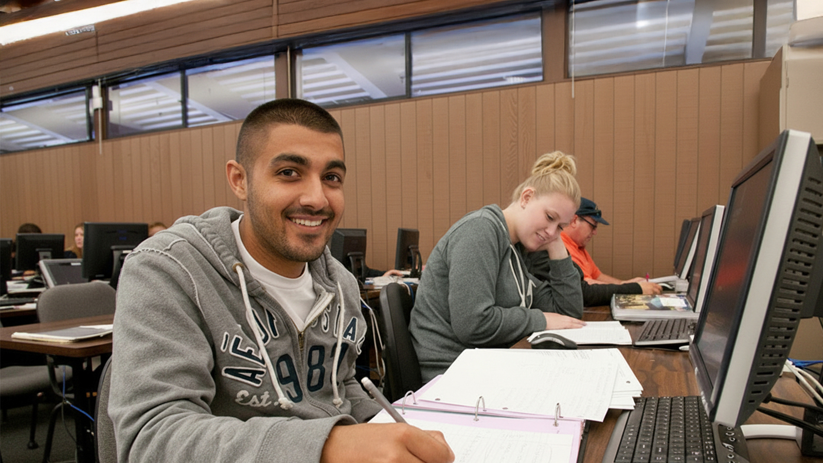 Male student at the classroom doing math