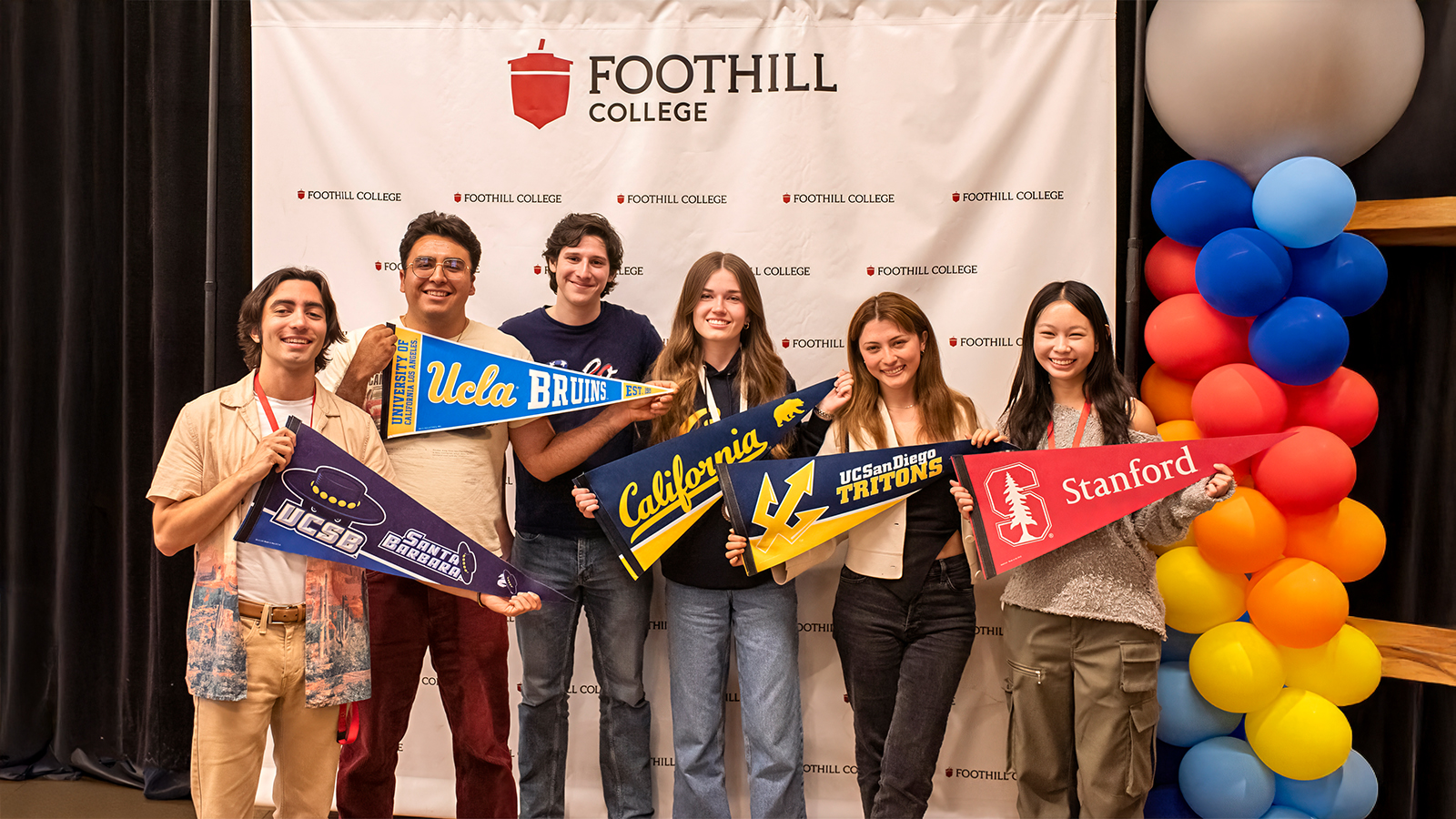 Diverse group of students showing different college pennants 